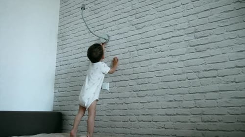 Child Plays near White Brick Wall Indoors
