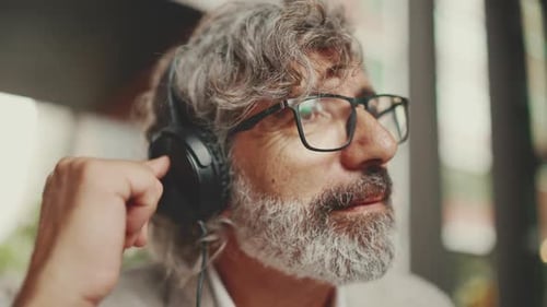 Clouse up, mature businessman ,wearing gray jacket makes conference video call on tablet pc