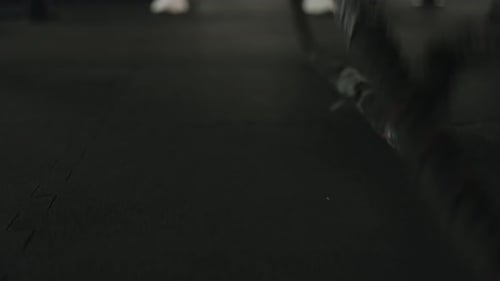 Man Exercising with Battle Ropes at Gym