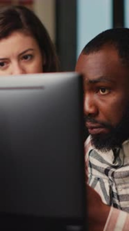 Colleagues Working Together on Computer in Office