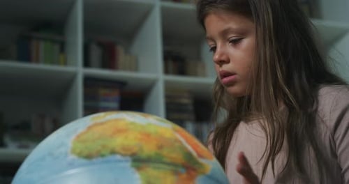 Focused Girl Looking at Globe