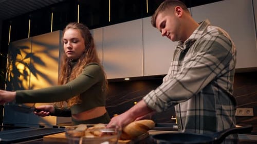 Young Couple Preparing Food and Kissing in Kitchen