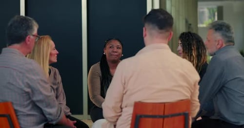 Support group gathered in circle as woman opens up, participants listening attentively