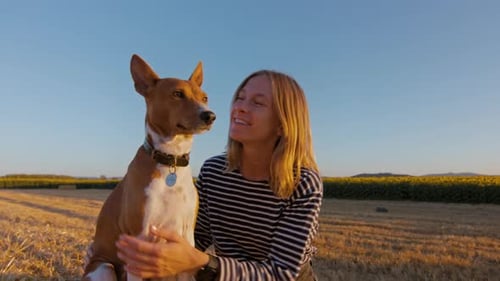 Woman and Dog in Sunset Light on Cinematic Field