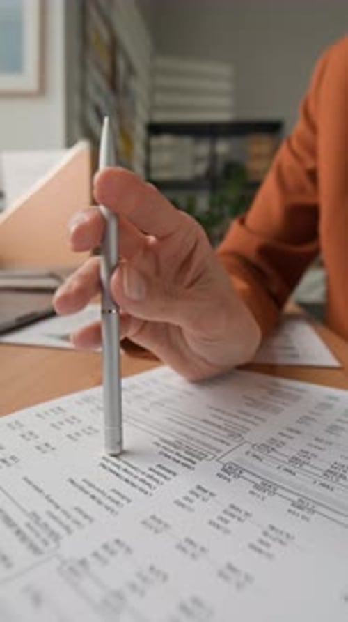 Hand Tapping Pen on Document During Review