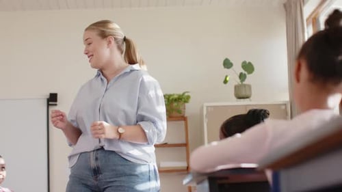In school, female teacher speaking to students in classroom, engaging with children