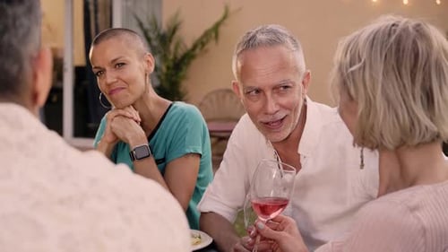 Group Adult Caucasian Attractive Friends Gathered Chatting Around Table in Garden on Summer Evening