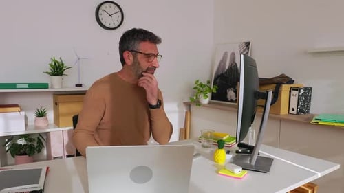 Happy Mature Businessman Working on Laptop in Modern Office