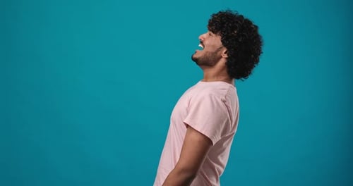 Handsome Indian Man Scream Yell with Hand Near Mouth Standing Isolated on Blue Studio Background