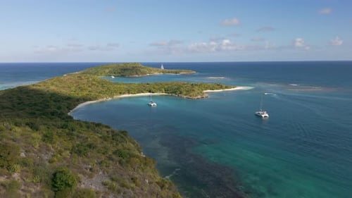 Aerial view of tropical island bay with catamarans in turquoise Caribbean water