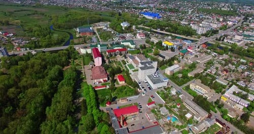Flight over the residential districts with blocks of flats and cottages, roads and green areas.
