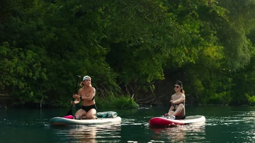 Women Rafting On River By Paddle Boards In Summer Vacation Active Pastime In Nature