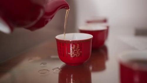 Pouring Traditional Chinese Tea from Red Teapot into Cups Slow Motion
