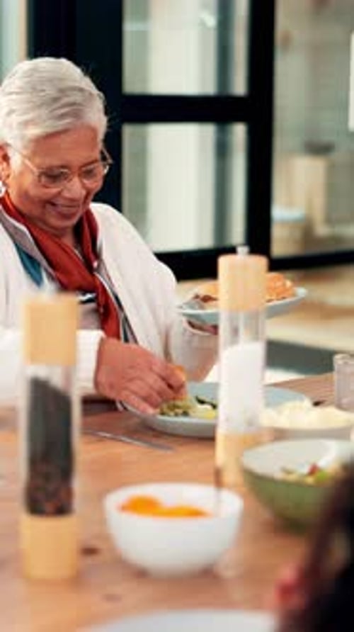 Smiling Senior Woman Preparing Food At Dining Table