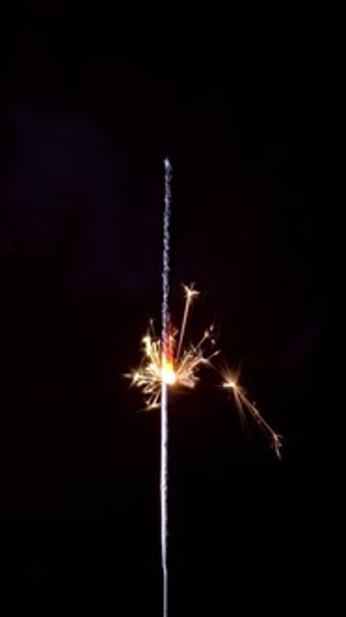 Sparkler Emitting Golden Sparks in the Darkness