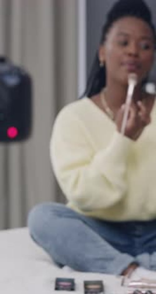 Influencer, tutorial y mujer negra con maquillaje en el dormitorio para aplicarlo, cómo hacerlo y hablar