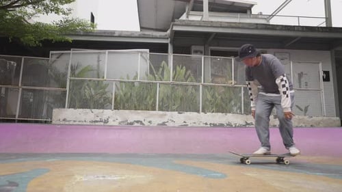 Man Skateboarder Skateboarding and Jumping 360 Flip Trick on Local Skatepark in Sunny Summer