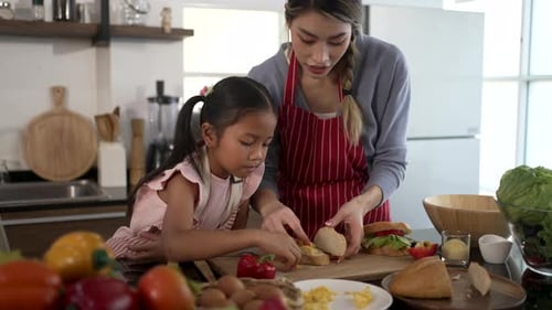 Child and Woman Making Sandwiches Together in Kitchen