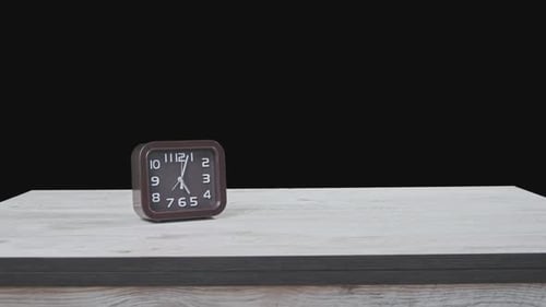 The Pointer Clock on Wooden Table and Black Background Show Time