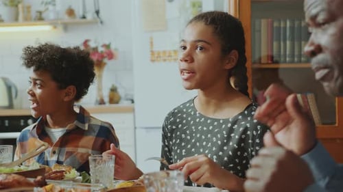 Kinder und Eltern essen und unterhalten sich zu Hause, Abendessen mit der Familie