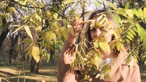 Portrait of Young Attractive Blonde Woman Walking in the Autumn Park on Sunset