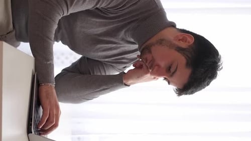 Thoughtful Man Works On Laptop At Home