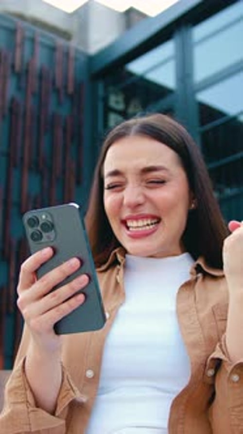 Close Up of Amazed Girl Holds Smartphone Happy to Receive Notification Gestures Actively From