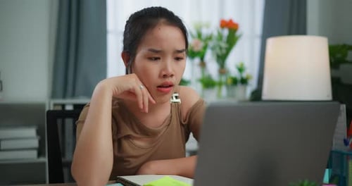 Thoughtful Woman Working on Laptop at Desk