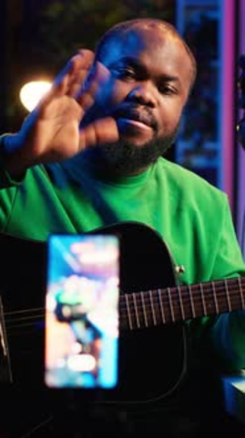 Vídeo vertical: Talentoso intérprete que enseña a tocar la guitarra acústica en línea para un tutorial