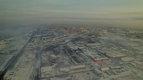 Winter Landscape View Over a Snowy Urban Area with Distant Buildings and Cloudy Sky