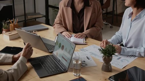 Three Middle-Aged Women Discussing Business During Meeting in Modern Office