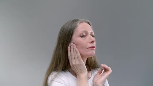Woman Applies Moisturizing Cream to Her Face