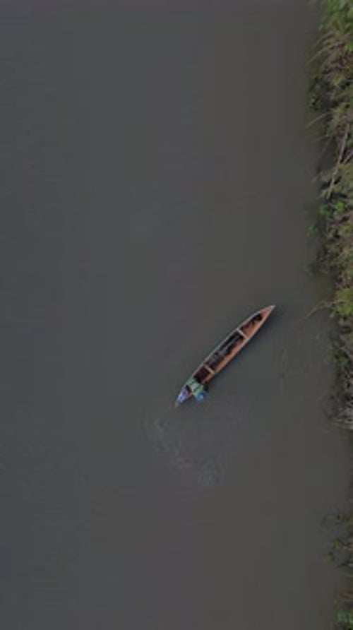 Drone vertical filmé par drone de petits bateaux de pêche flottant sur la rivière dans la forêt