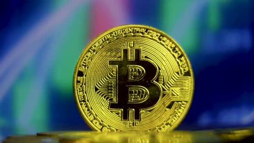 Close Up Shot of BTC Coin With Candlestick Trading Graph Background