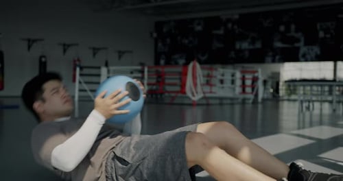 Portrait of Asian Sportsman Doing Intensive Training Abdominal Crunches Exercise with Ball Working
