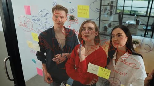 Team Brainstorming Together at Office with Glass Board