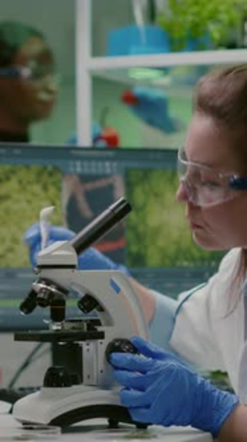 Woman Using Microscope in Lab Environment