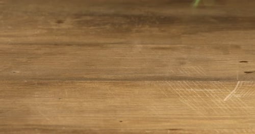 Woman putting bunch of fresh dill on wooden table, closeup