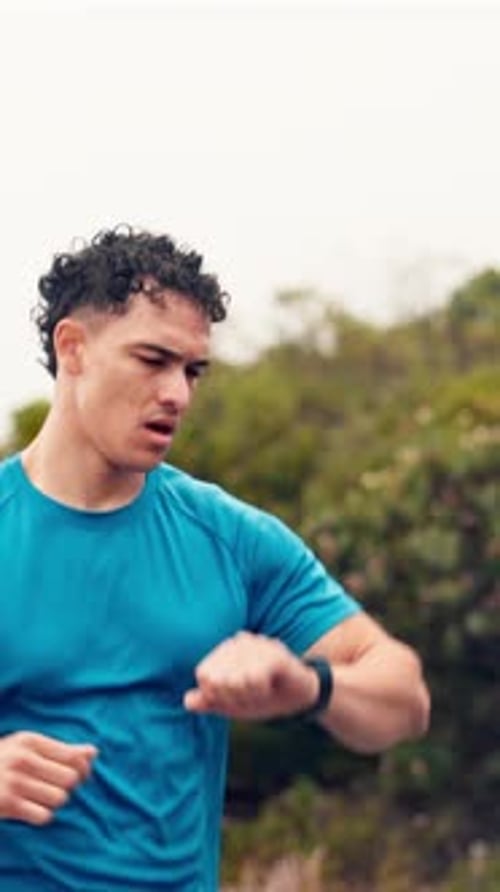 Athletic Young Man Running and Checking His Smart Watch