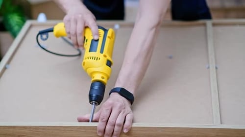 Furniture Manufacturing Industry Craftsman Uses Drilling Machine to Make Holes on Back of Cabinet