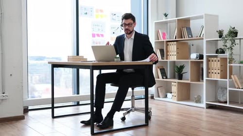 Businessman Presenting Marketing Report with Growth Chart in Modern Office