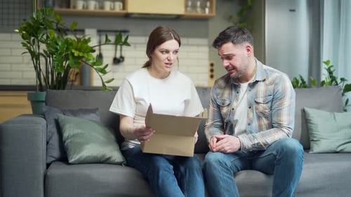 Young Couple Opening a Baby Shower Gift