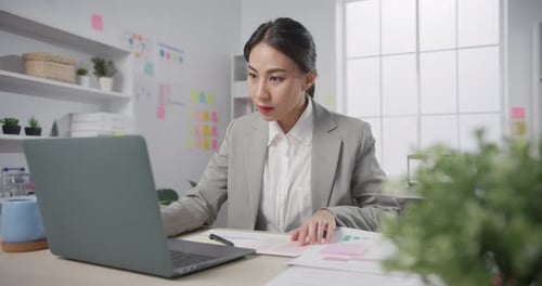 Young Woman Working on Laptop in Office