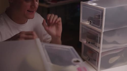 Man Sorting Through Shoes in Storage Containers