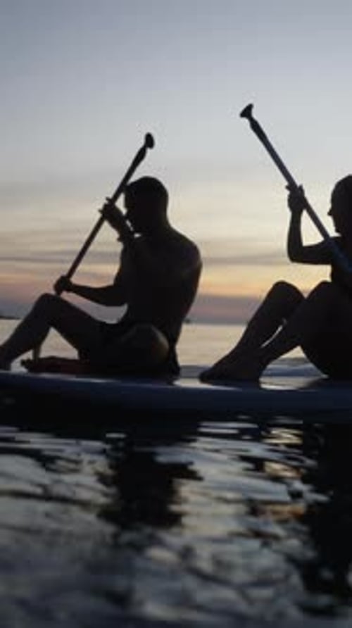 Couple Paddling Their Paddle Surf Board on a Beach in Koh Tao