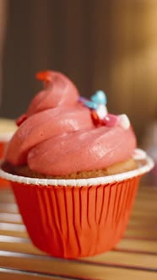 Colorful Sprinkles Added to a Frosted Cupcake