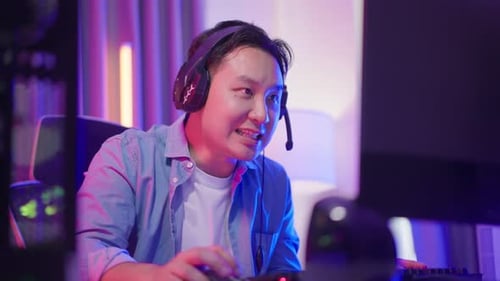 Enthusiastic Gamer Playing Online with Headset and Computer