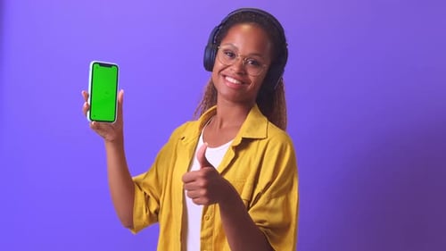 Young Happy African American Woman Shows Green Screen Phone and Gives Thumbs Up