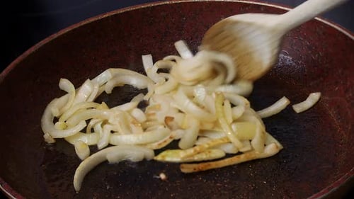 Sliced Onions Being Sauteed in Frying Pan