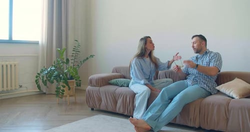 Couple Arguing on Couch in Living Room